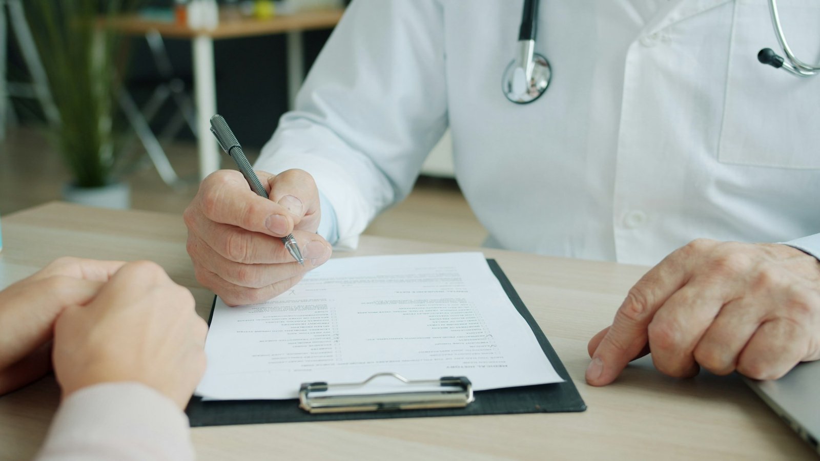 Clinician writing notes on a clipboard