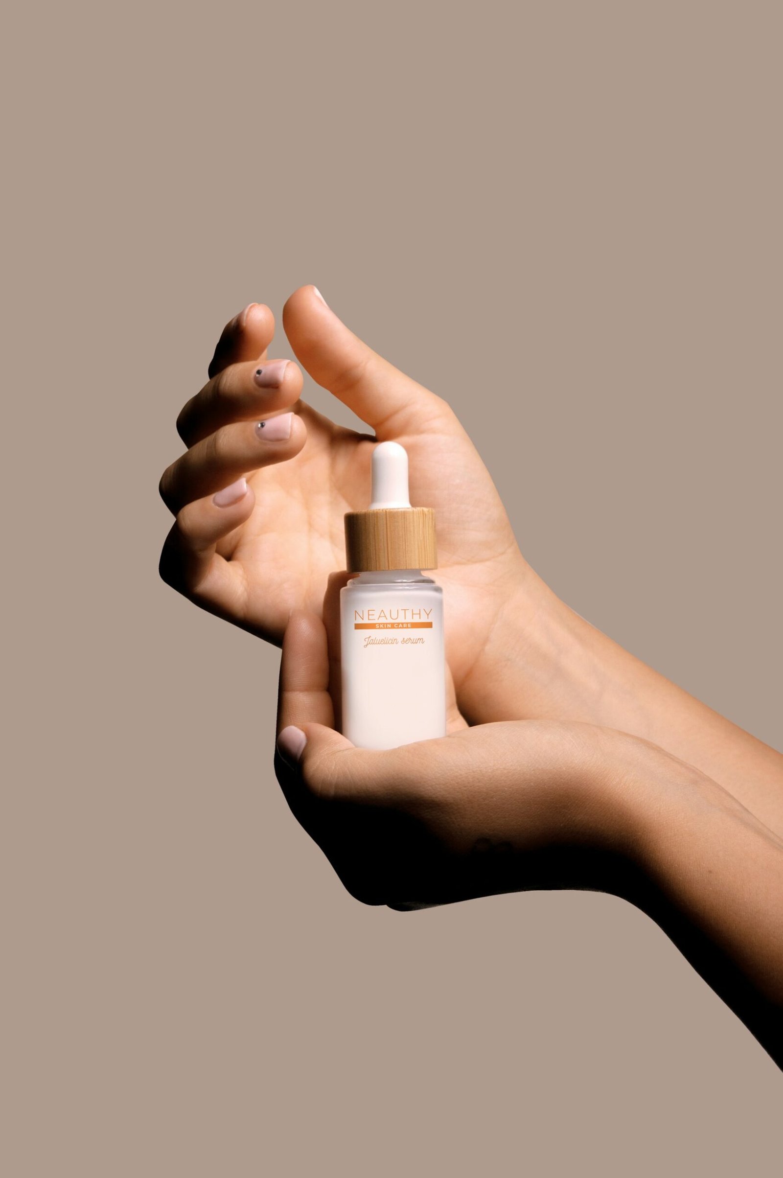 Hands holding a serum bottle